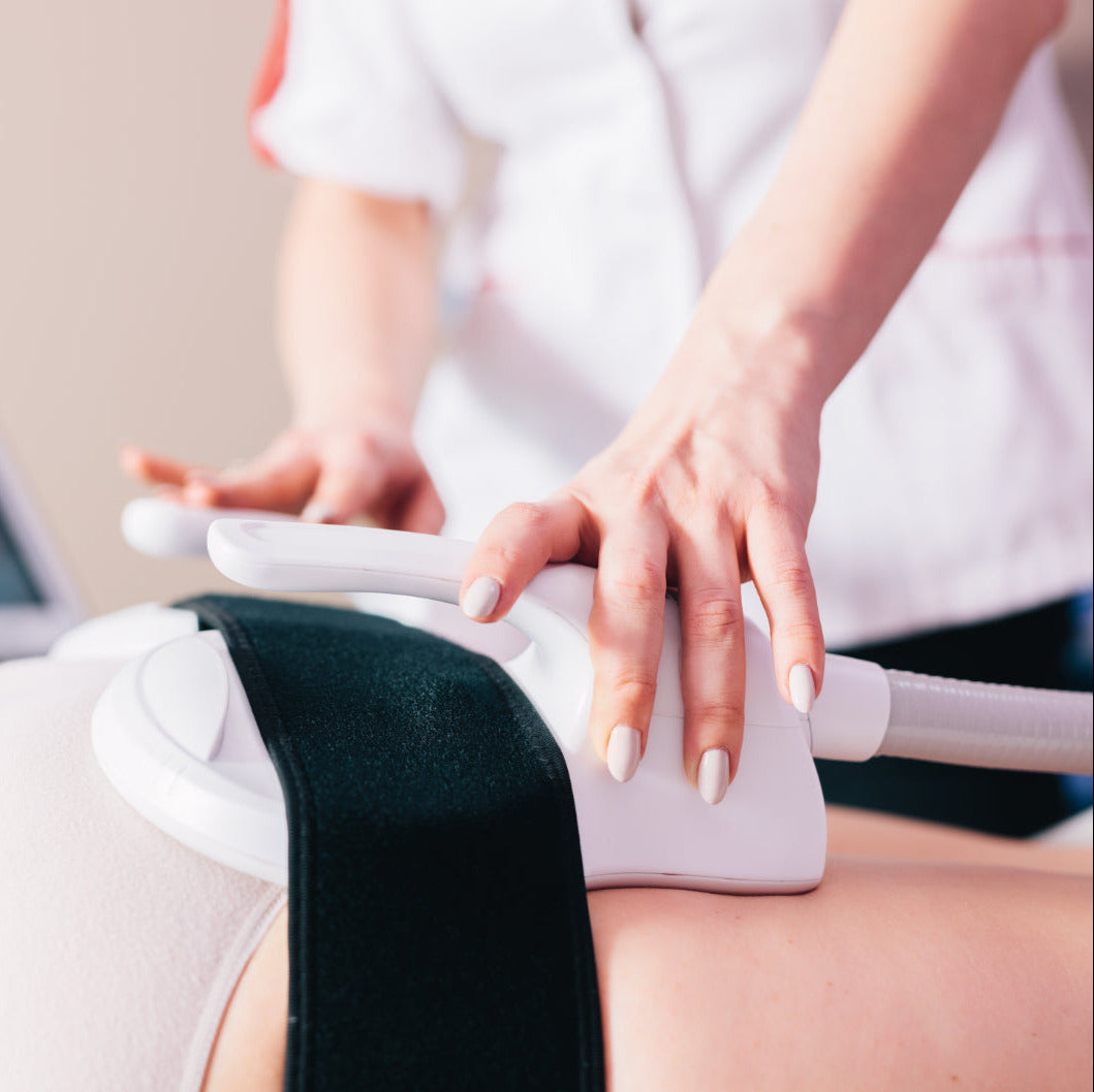 Person receiving a laser treatment on their leg with a healthcare professional.